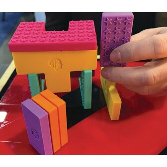 Close-up van de Geri-Gadgets Shapes Bucket met kleurrijke siliconen vormen, ideaal voor vormherkenning en motorische stimulatie