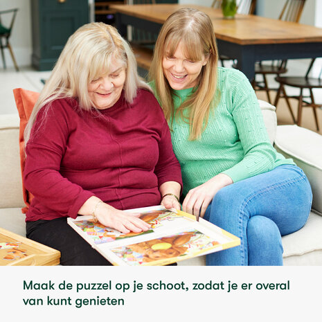 Twee vrouwen, waarvan één met dementie, genieten samen van het maken van een Relish puzzel op schoot — soc