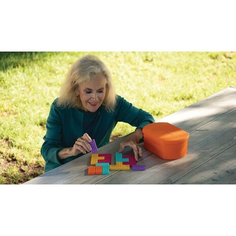 Oudere vrouw geniet van het sorteren van de zachte siliconen vormen uit de Geri-Gadgets Shapes Bucket, een rustgevende en herke