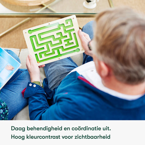 Oudere man met dementie houdt het knikkerdoolhof vast &ndash; stimuleert co&ouml;rdinatie, motoriek en focus op een veilige 